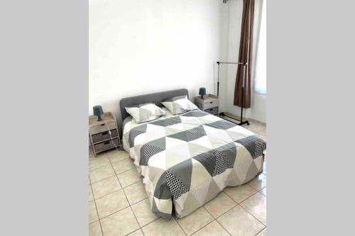 une chambre avec un lit avec une couette noire et blanche dans l'établissement Bel Appartement - HYPER CENTRE - 2 pièces, à Cannes