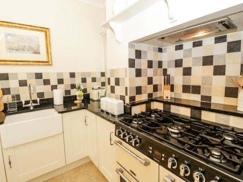 a kitchen with a stove and a sink at Min Y Don in Colwyn Bay