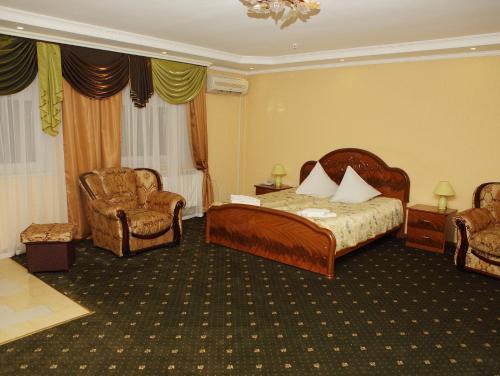 una camera d'albergo con un letto e due sedie di ВІКОНТ a Chishki