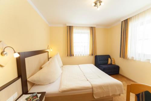 een hotelkamer met een bed en een stoel bij Appartements Höller in Kleinarl