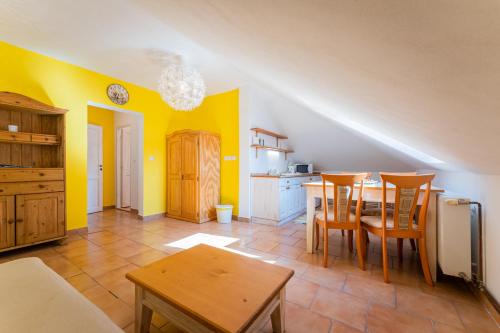 a kitchen with yellow walls and a table and chairs at Penzion U Babky bylinkářky in Kutná Hora