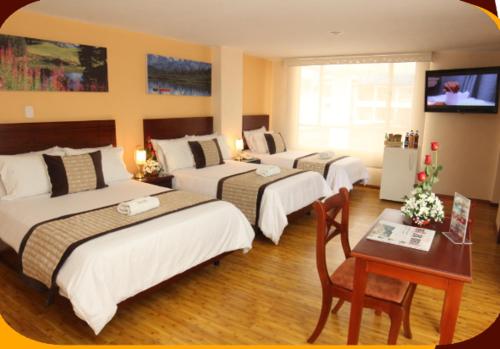 a hotel room with four beds and a table and a television at Hotel Xilon Resort Pasto in Pasto