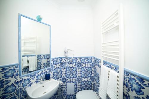 een blauwe en witte badkamer met een wastafel en een toilet bij SWEET SORRENTO HOLIDAYS in Sorrento