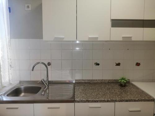 eine Küche mit einer Spüle aus Edelstahl und weißen Schränken in der Unterkunft Apartment Vera, 80 m from the sea in Novigrad Istria