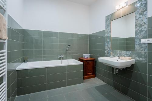 a bathroom with a bath tub and a sink at Penzion U Babky bylinkářky in Kutná Hora