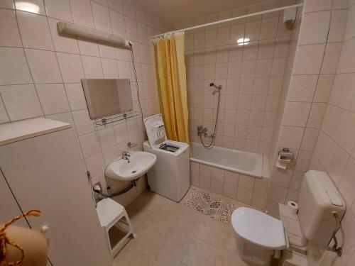 ヘーヴィーズにあるRómai Therme Apartmanのバスルーム(洗面台、トイレ、バスタブ付)