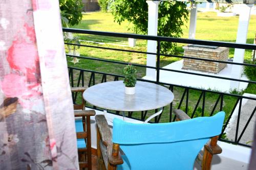 a table and chairs on a balcony with a potted plant at Utopia Kavos in Kavos