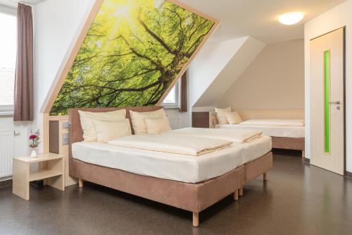 a bedroom with two beds and a painting on the wall at Radlhotel Wassertrüdingen in Wassertrüdingen