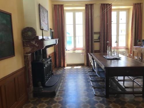 Un comedor con mesa y chimenea. en Maison La vie est belle, en Luc-sur-Orbieu