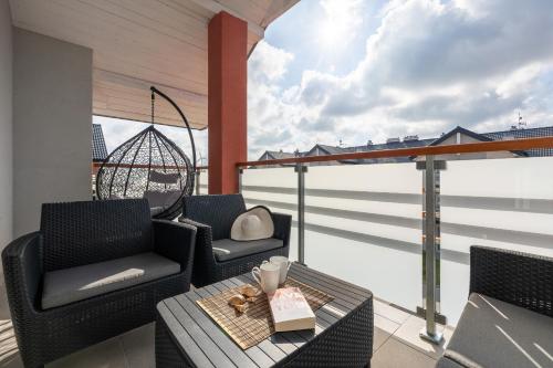 a balcony with two chairs and a table at Apartamenty Północna by Renters in Darłowo