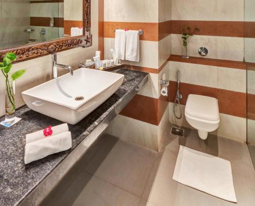 a bathroom with a sink and a toilet at Club Mahindra Acacia Palms in Colva