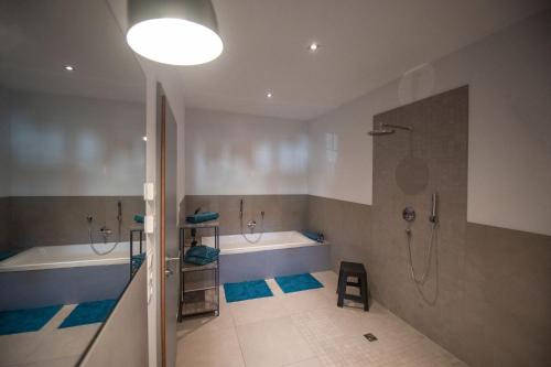 a bathroom with two tubs and a shower and a sink at Sudhaus/Alte Brauerei in Meisenheim