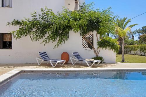 
a patio area with a pool, chairs, and a lawn chair at Pedra Mansa Nr 1 in Carvoeiro

