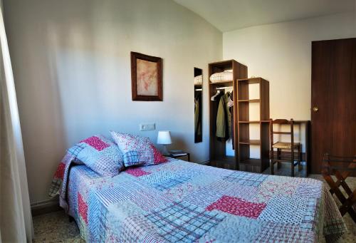 1 dormitorio con 1 cama con edredón en Casa Rural Tobal en Castellote