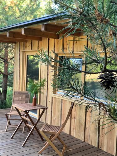a wooden deck with a table and a chair at Boutique Glamping Divja DiVine in Zgornja Korena