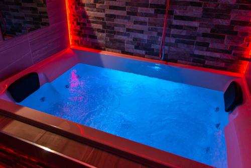 una vasca idromassaggio in una stanza con luci rosse di Optimal Apartments a Bradford