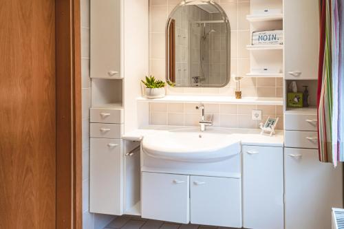 a bathroom with a sink and a mirror at Ferienhaus Meldorf in Meldorf