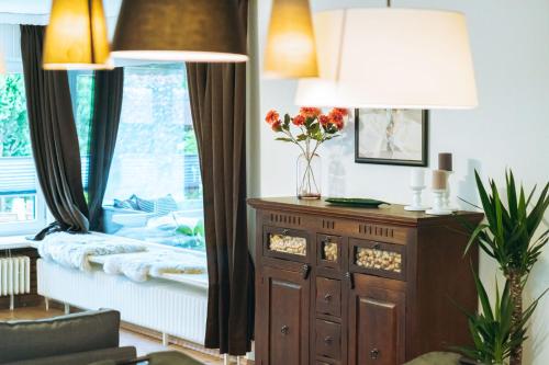 a living room with a window and a table with flowers at Ferienhaus Meldorf in Meldorf