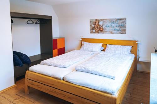 a bedroom with a large bed with a wooden headboard at Ferienhaus Meldorf in Meldorf