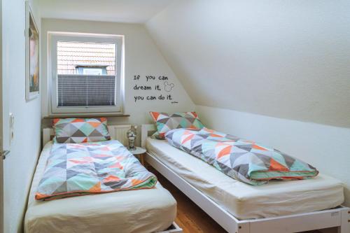 two beds in a small room with a window at Ferienhaus Meldorf in Meldorf