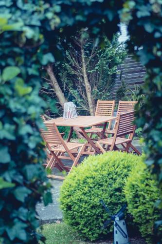two chairs and a wooden table in a garden at Ferienhaus Meldorf in Meldorf