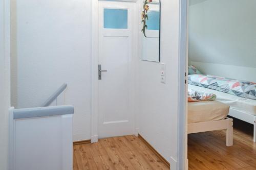 a small room with a door and a bed at Ferienhaus Meldorf in Meldorf