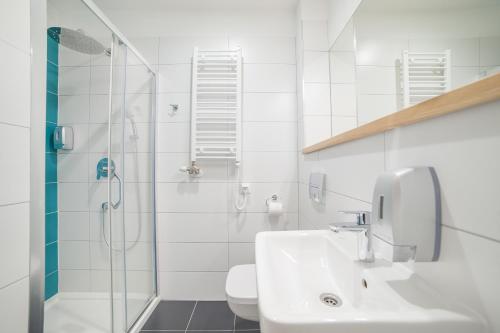 a white bathroom with a sink and a shower at Hotel Traffic Wrocław Stare Miasto in Wrocław