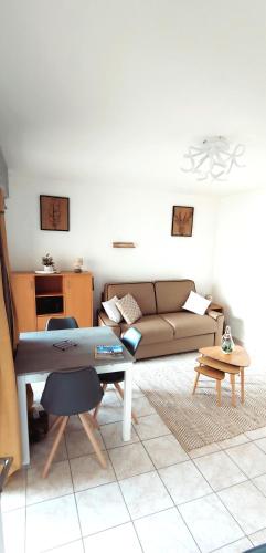 un soggiorno con un divano e un tavolo di RESIDENCE CEZANNE a Gréoux-les-Bains