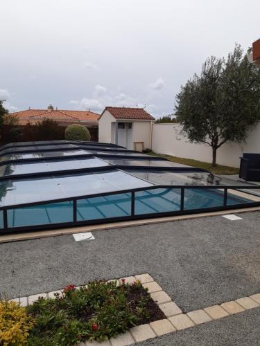a swimming pool with blue glass in a parking lot at Chambre d'hôte le Bois Joli in Brains
