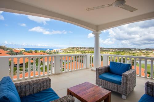 a balcony with chairs and a table and a view at Blue Bay Apartments in Sint Michiel