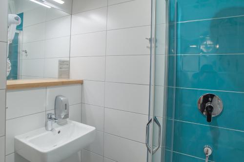 a bathroom with a sink and a shower at Hotel Traffic Wrocław Stare Miasto in Wrocław
