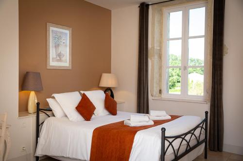 a bedroom with a large bed with a window at Le Clos de la Tuilière in Grignan