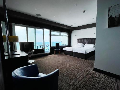 a hotel room with a bedroom with a bed and a television at Suncliff Hotel - OCEANA COLLECTION in Bournemouth