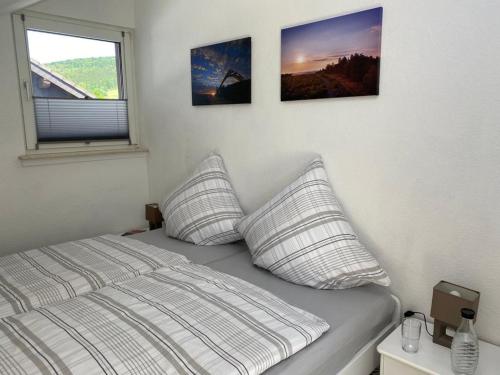 um quarto com uma cama com três fotografias na parede em Ferienwohnung Frieda mit überdachtem Balkon em Winterberg