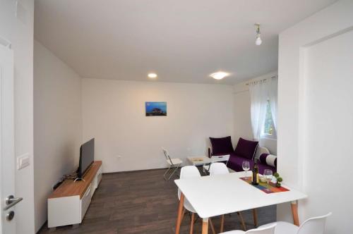 ein Wohnzimmer mit einem weißen Tisch und einem Sofa in der Unterkunft Apartments Nina Tivat in Tivat