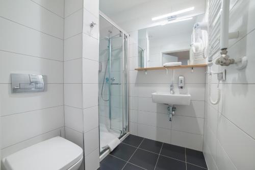 a bathroom with a shower and a toilet and a sink at Hotel Traffic Wrocław Stare Miasto in Wrocław