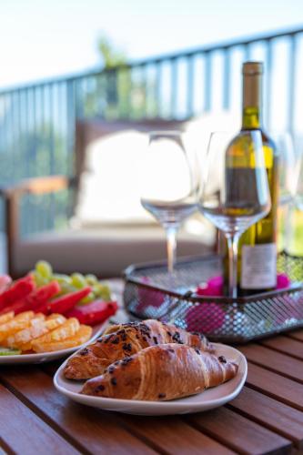 a table with two plates of food and a bottle of wine at Apartment Lea in Stanići