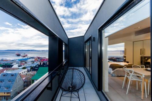 a balcony with a chair and a view of the water at Austral Departamentos in Ushuaia