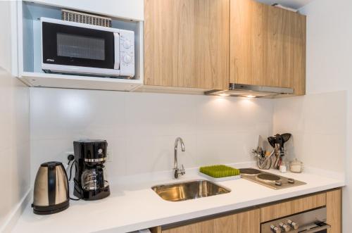 a kitchen with a sink and a microwave at Austral Departamentos in Ushuaia
