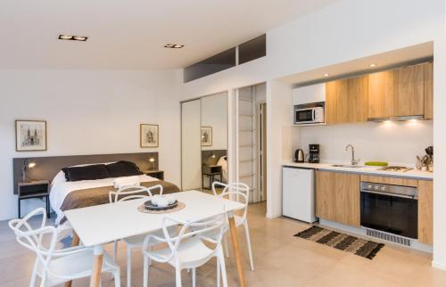 a kitchen and living room with a bed and a table at Austral Departamentos in Ushuaia