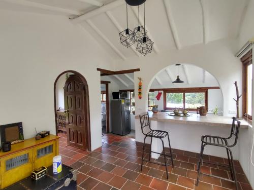 萊瓦鎮的住宿－Hacienda El Pinar del Viento，一间厨房,内设两把椅子和柜台