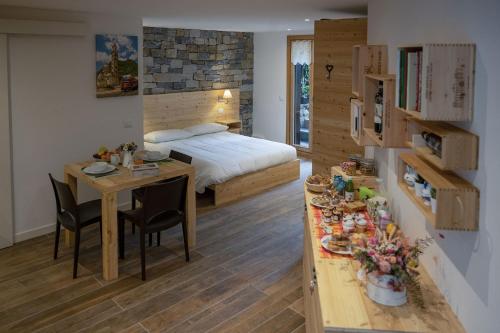 a bedroom with a bed and a table with chairs at Casa Galèt in Tirano