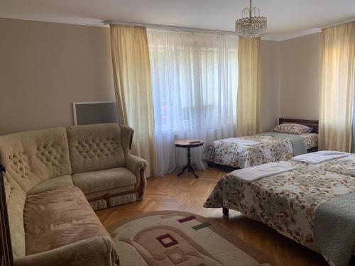 a living room with a couch and two beds at Celebrity in Kamianets-Podilskyi