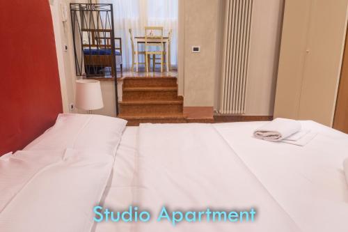 a bedroom with two white beds and a staircase at BolognaRoomscom - Santo Stefano Apartments in Bologna
