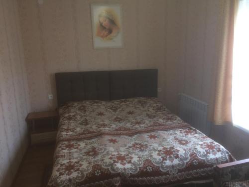 スキュネイザにあるБудиночок в Східнці-Новий Кропивникのベッドルーム1室(花の咲く毛布付きのベッド1台付)