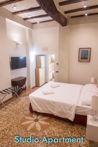 a bedroom with a bed and a desk in a room at BolognaRoomscom - Santo Stefano Apartments in Bologna