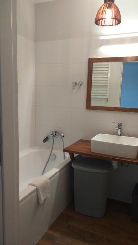 a bathroom with a tub and a sink and a mirror at Sailor Apartment - Wyjątkowe Miejsce in Kołobrzeg