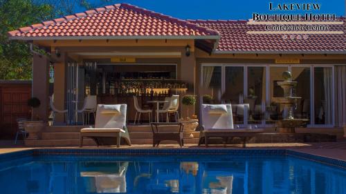 a pool with chairs and a bar next to a building at Lakeview Boutique Hotel & Conference Center in Benoni