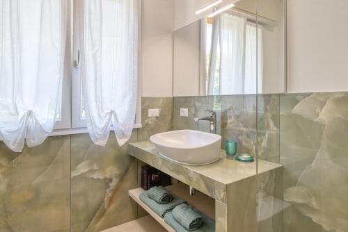 a bathroom with a sink and a mirror at La Sensa Apartments in Brenzone sul Garda