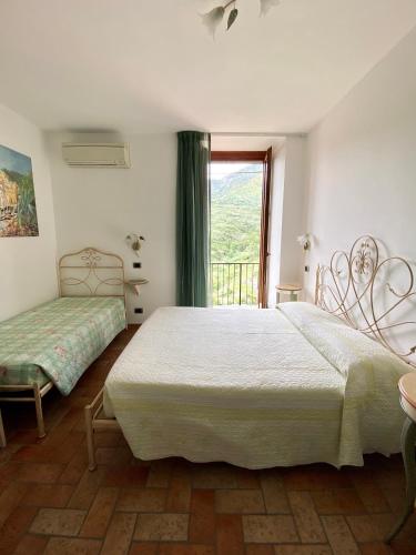 a bedroom with two beds and a window at Sandra Villa Rooms in Corniglia